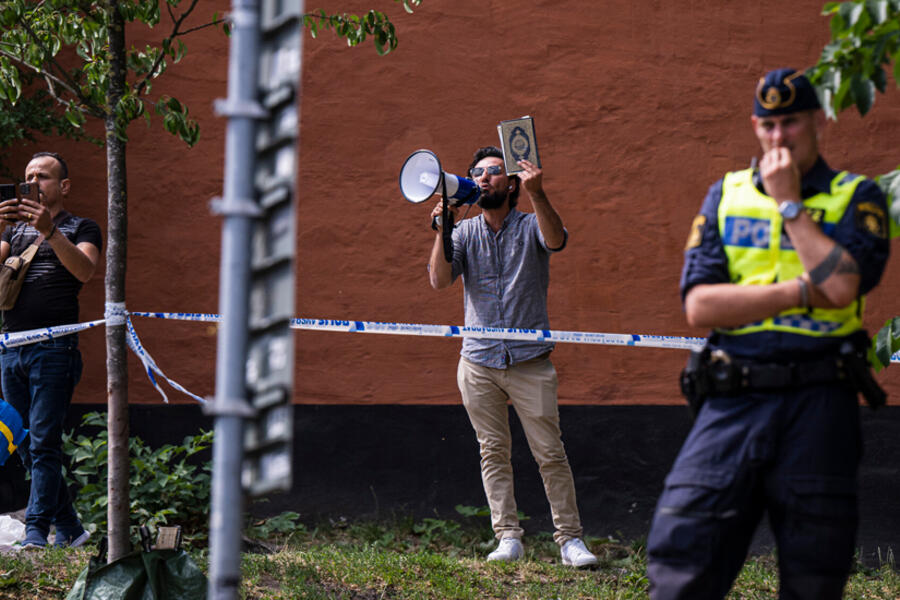 Salwan Momika sostiene un Corán frente a una mezquita en Estocolmo el 28 de junio de 2023, durante la festividad de Eid al-Adha. Foto: AFP.