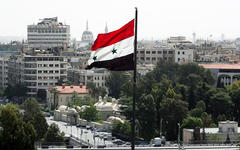 Bandera siria ondea en Damasco, abril de 2019. Foto: AFP.