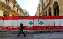 Un hombre pasa frente a barreras de concreto cerca del parlamento en Beirut. (Reuters)