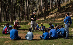 Louis Junior Saad, centro, y Martin Kaech, agachados a la izquierda, voluntarios de la Sociedad para la Protección de la Naturaleza en el Líbano, hablan con boy scouts sobre la migración de aves y la caza ilegal. (FOTO: Diego Ibarra Sanchez)