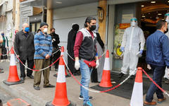 Clientes usan máscaras faciales y guantes afuera de un supermercado en Beirut, Líbano. (REUTERS).