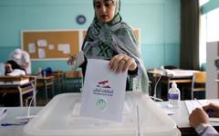 Un trabajador electoral muestra una a los representantes de los candidatos parlamentarios, después del cierre de un colegio electoral, en Beirut, Líbano, el domingo. Foto: AFP.