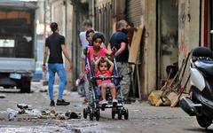 Una niña empuja un cochecito a lo largo de un callejón en el barrio Bab Al Tabbaneh, en la ciudad norteña de Trípoli, Líbano, el 3 de junio de 2020. AFP.