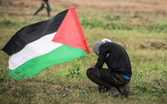 Un palestino sostiene una bandera durante una protesta dentro de las manifestaciones de la "Gran Marcha del Retorno" y el "Día de la Tierra Palestina" en el este del barrio de Shuja'iyya, Gaza, el 30 de marzo de 2019. Foto: Agencia Anadolu.