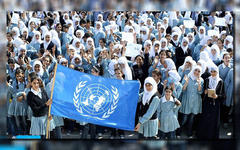 Niños en Gaza posan con la bandera de UNRWA (Foto: Days of Palestine).