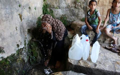 Una mujer palestina llena un bidón con agua de manantial en Salfit, al norte de Ramallah.