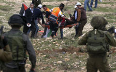 Manifestantes palestinos transportan a un herido en los enfrentamientos con las fuerzas israelíes en la conmemoración del Día de la Tierra en la aldea de Madama, Palestina ocupada, Marzo 30, 2017.