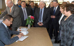 Embajador Adnan Mansour firmando copias durante la presentación.