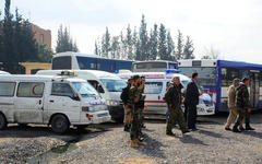 Ambulancias y micros listos frente a la entrada del corredor humanitario abierto por el Ejército Árabe Sirio para los civiles de Ghouta Oriental.