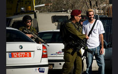 Colono israelí armado dando la mano a soldado (Foto LAntinori)