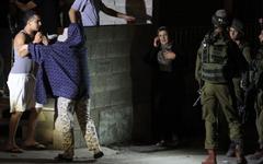 Soldados israelíes interrogan a una familia palestina durante un allanamiento en Ramallah Foto: AFP